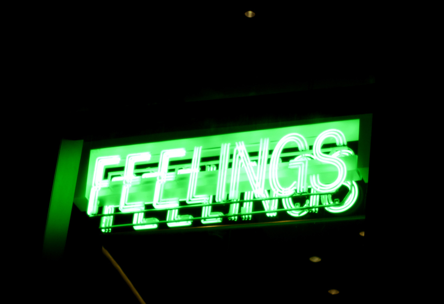 A green neon sign that reads "Feelings"